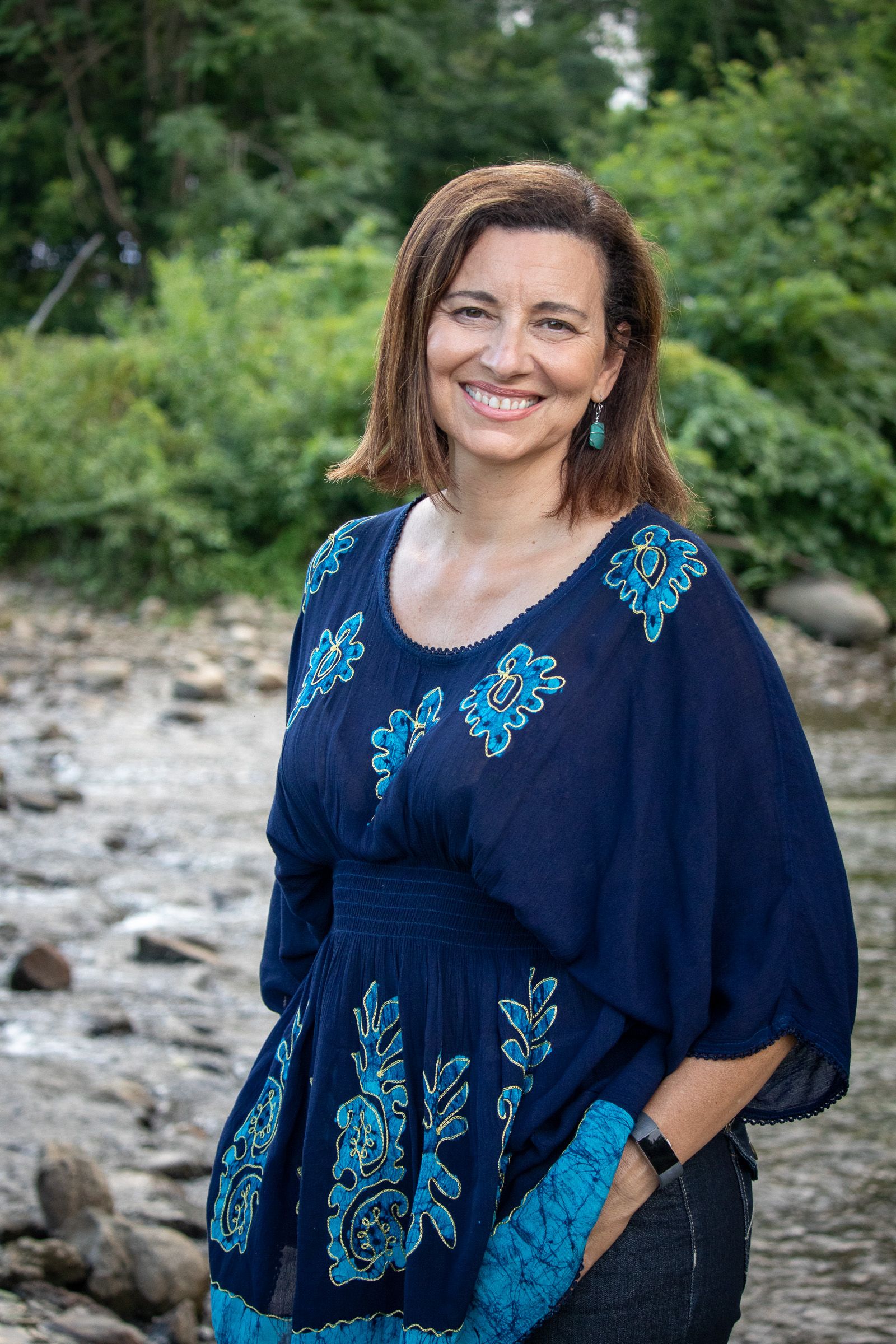 Woman in a blue dress by a river