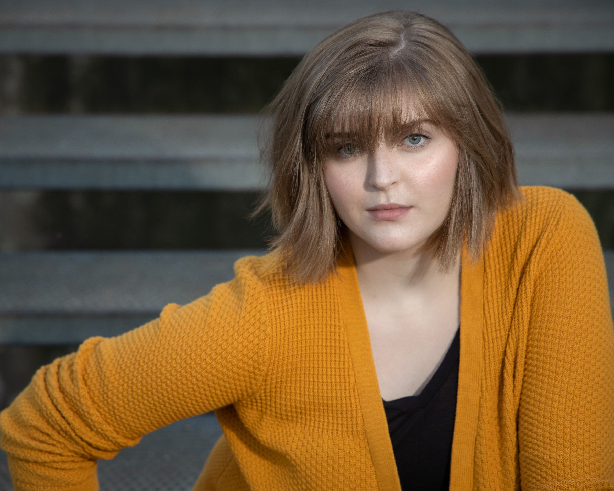 Senior portrait with a mustard sweater and warm fall background